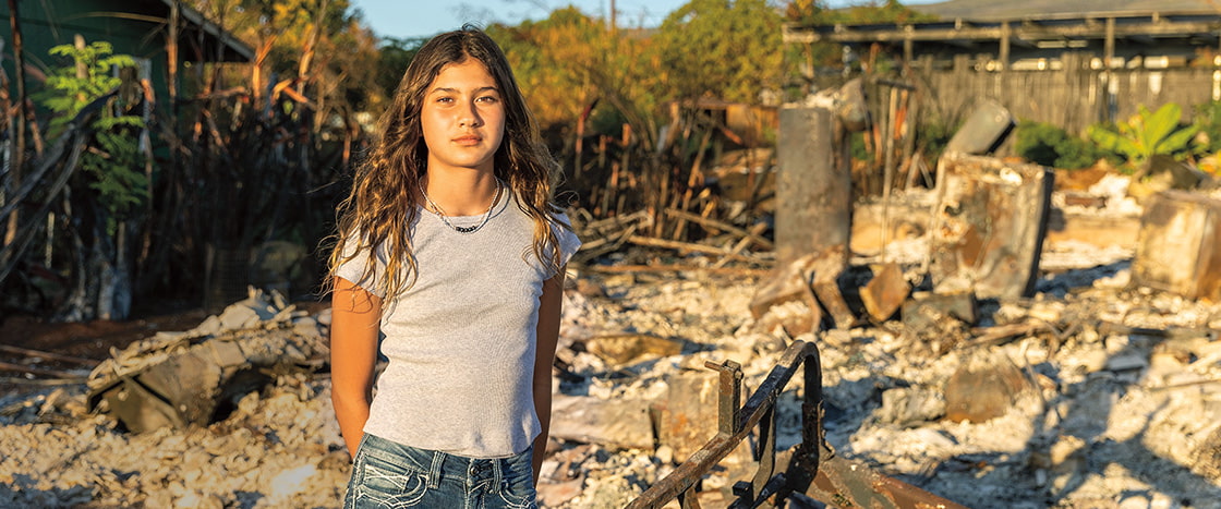 Image of a kid standing in front of rubble