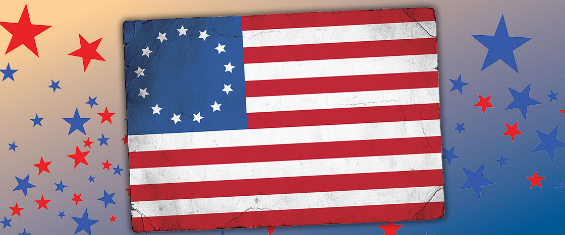 The Betsy Ross flag with 13 stars arranged in a circle, surrounded by red and blue stars